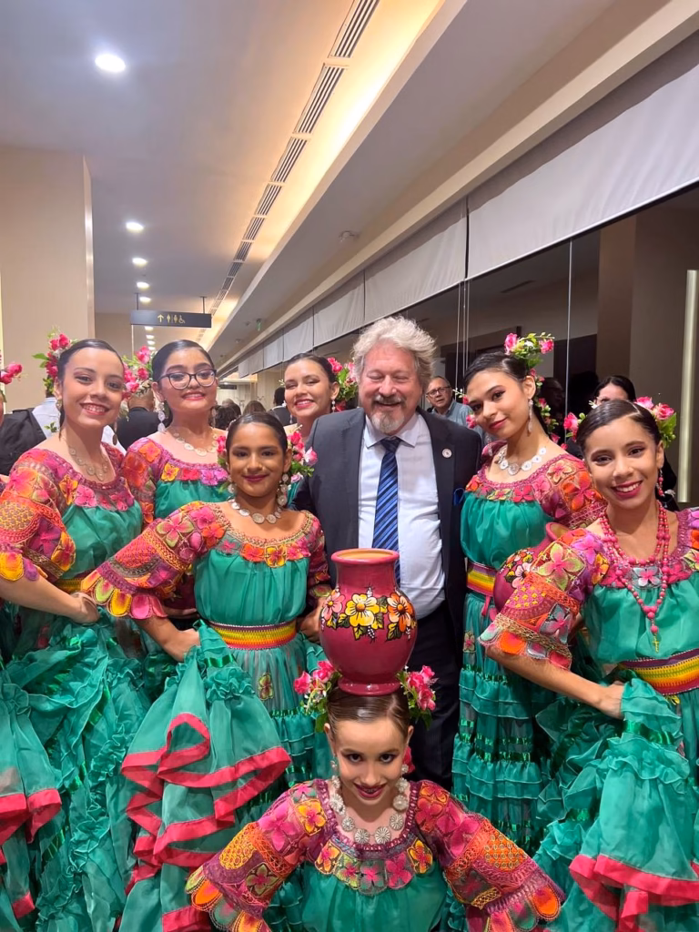 El Dr. Julio Heinichen, presidente del congreso, con el grupo de danza paraguaya, Asunción 2024